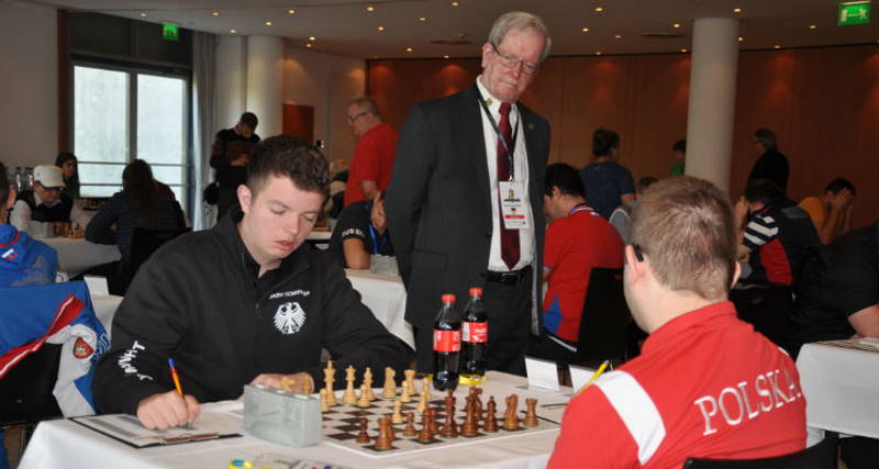Une arbitre homme surveille un tournoi d'échecs